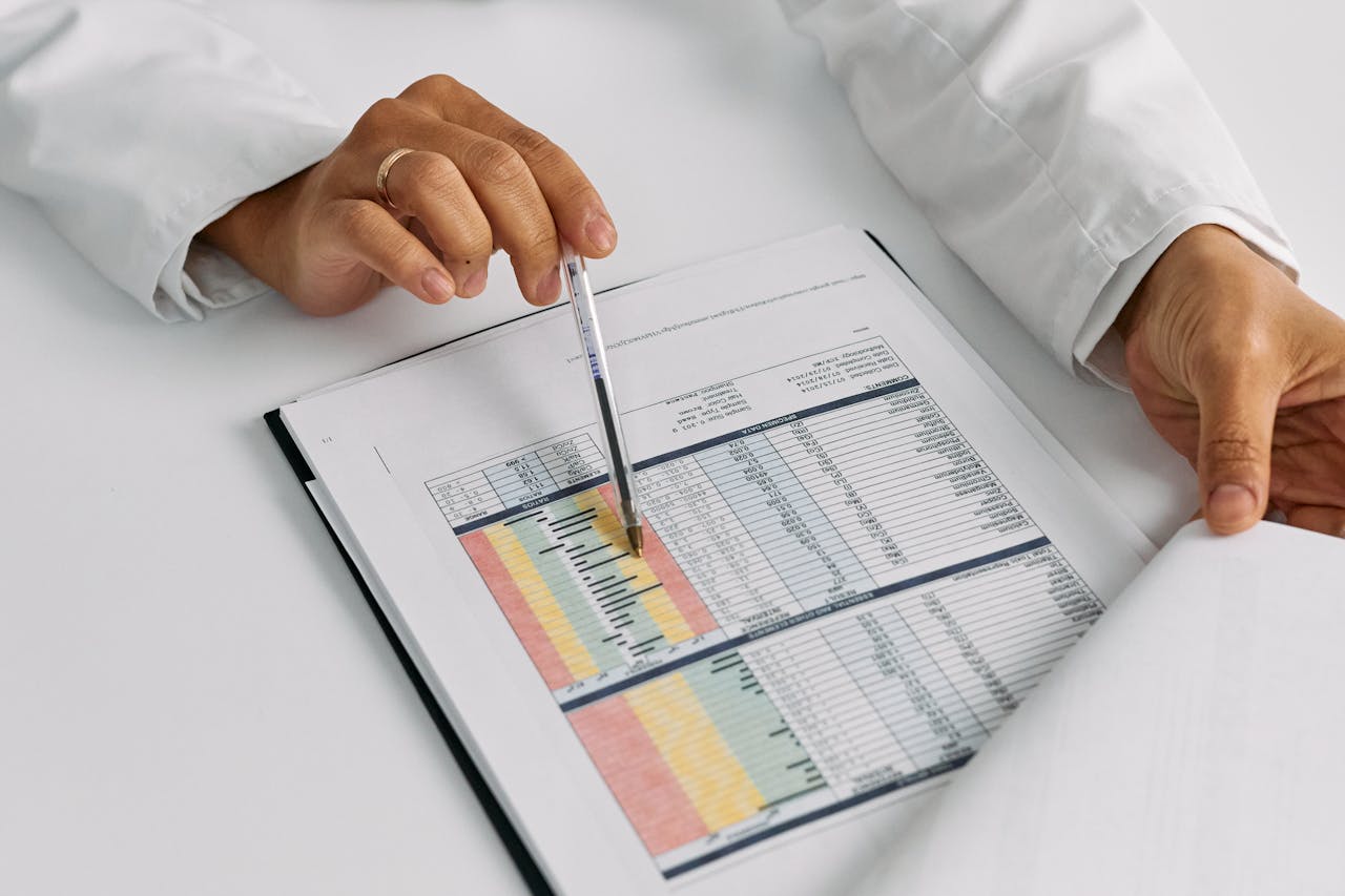 Doctor hands examining and pointing at medical charts in a close-up view.